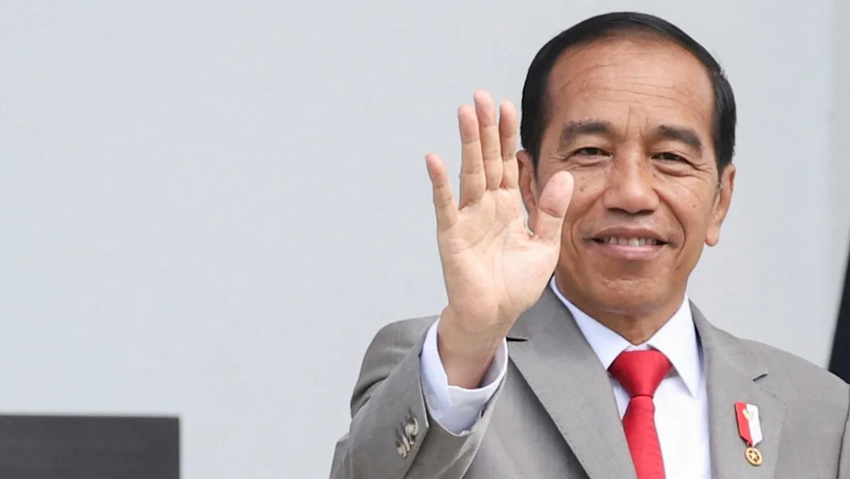 Mantan Presiden Joko Widodo menunjukkan kartu keanggotaan PSI di Bandung