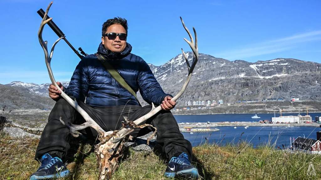 Pekerja migran asal Filipina GP Dupitas berpose dengan rusa buruan di ibu kota Greenland Nuuk