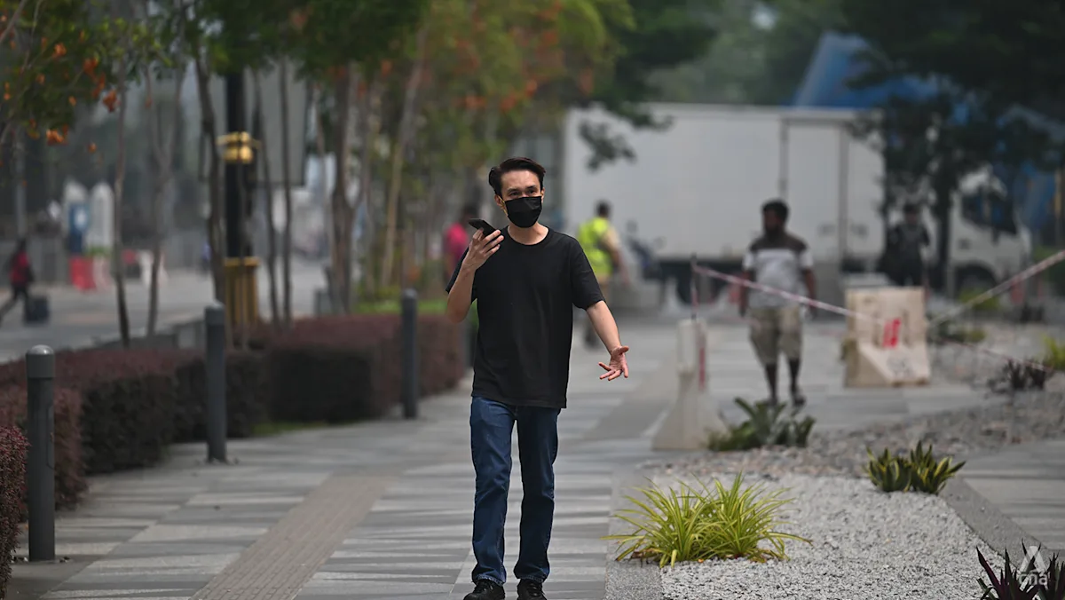 Seorang pria mengenakan masker di tengah kondisi kabut asap di Johor Bahru
